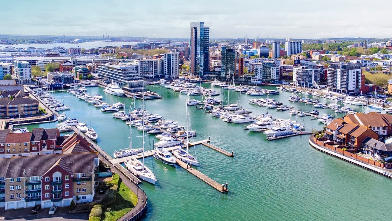 A modern cruise terminal with a large ship docked in the background