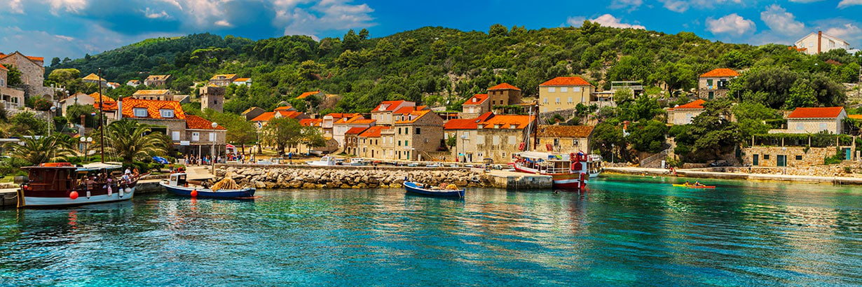 A harbour village and wooded hills on the Dalmatian coast