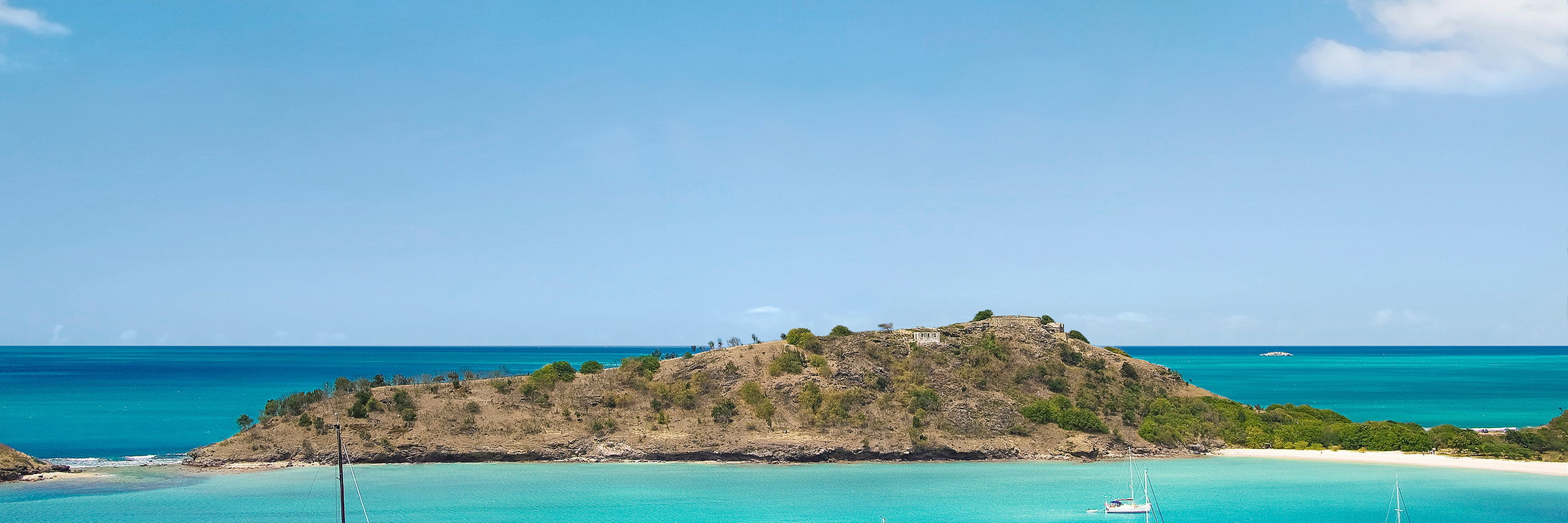 A wooded headland jutting into a turquoise sea, Antigua
