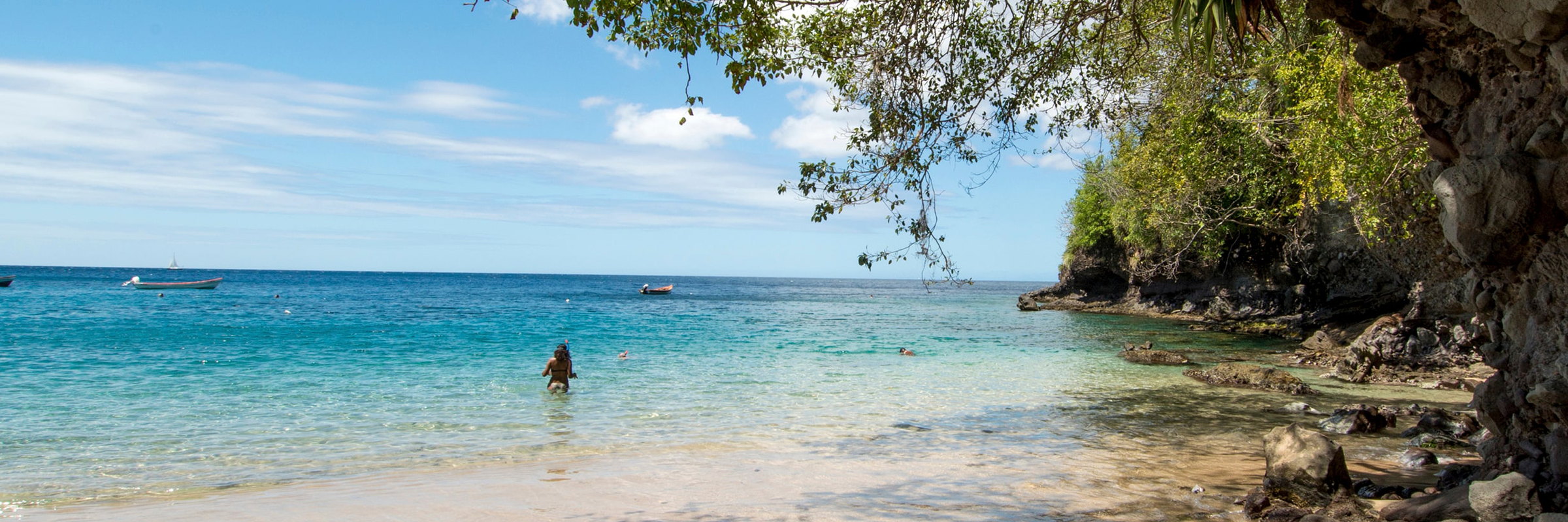 A rocky headland, a pale beach and turquoise sea in Martinique