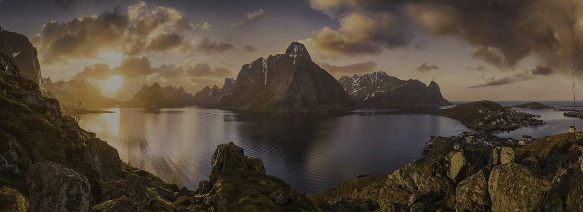 A fjord at golden hour — mountain, water and a shoreline village
